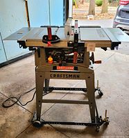Front view of table saw on stand showing overall appearance and wheels