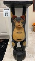 Front view of the carved wooden cat table showing full figure and top surface.