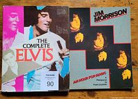 Front cover of two photobooks; The Complete Elvis with colorful design and Jim Morrison An Hour For Magic with multiple images of Jim Morrison.