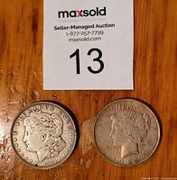 Front view of 1921 Morgan silver dollar and 1922 Peace silver dollar coins showing Liberty profiles.