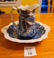 Jug and bowl set displayed on table, showing blue and white traditional scenic transferware design typical of Old Foley pottery.