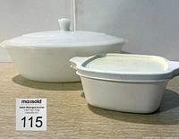 Front view of two white casserole dishes, one large oval USA Glassbake with lid and one small square Corning Ware with lid.