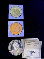 Three commemorative US coins: eagle design coin, Morgan silver dollar replica, Franklin D. Roosevelt coin with certificate