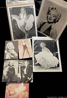 Three vintage 8x10 black and white photos and five black and white postcards of Marilyn Monroe, showing iconic poses and portraits, packed in plastic sleeves for protection.