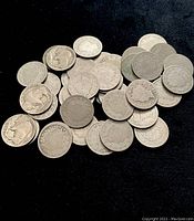 Pile of mixed US nickel coins showing Buffalo, Liberty, and V nickel designs from early 1900s.
