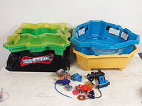 Full lot view showing two BeyWheelz battle arenas and Beyblade accessories spread in front.