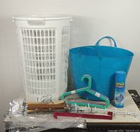 All items including laundry baskets, assorted hangers, coat hooks, and spray starch on table.
