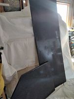 Two rectangular dark blue laminate countertop pieces with flecked pattern, one larger and one smaller, displayed leaning against a white backdrop.