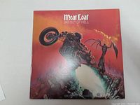 Front of Meat Loaf Bat Out Of Hell album cover showing artwork with motorcycle and winged figure.