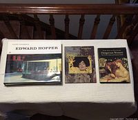Top view of three art books placed side by side on table.