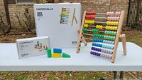 Table outdoors with assembled wooden abacus and set of wooden blocks with packaging boxes visible