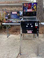 Front view of the assembled digital pinball machine with box in background