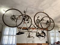 Two Ross brand road bicycles hanging from a garage ceiling, showing overall condition and storage method.