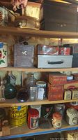 Shelves holding various vintage tins, metal boxes, glass bottles, and canisters showing condition and specific items