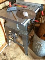 Full view of the Craftsman table saw showing metal frame, saw blade mounted on the work surface, fence, and power cable.