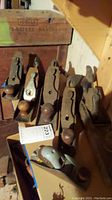 Lot of six vintage woodworking hand planes of varying sizes, mostly wooden-bodied, showing rust and wear.