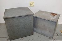 Both galvanized milk boxes side by side showing relative sizes and embossed dairy names.
