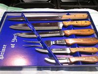 Full view of the six-piece cutlery set inside the box showing different blade and fork types with wooden handles.