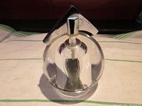 Front view showing clear round acrylic body and chrome angled top handle.