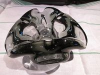 Top angled view of organic flowing black and clear Murano style ashtray showing swirling glass design and depth of bowl.