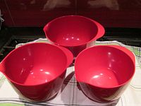 Three red mixing bowls shown separately to display interiors and sizes.