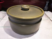 Side view of the Wedgwood stoneware casserole dish with lid, showing matte olive green finish and round knob handle on lid.