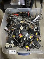 Large plastic bin filled with assorted hand tools and tool holders, tags and packaging visible indicating mostly new condition.