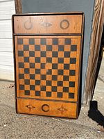 Front view of the large vintage chess and checker board showing the playing surface and decorative inlays on wood border.