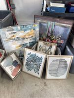 Six framed modern art prints including abstracts, florals, and geometric themes gathered on the floor