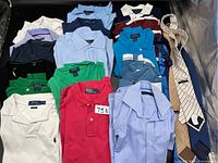 Top-down view of multiple folded Polo Ralph Lauren polo shirts and several neckties arranged on a surface.
