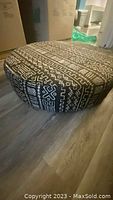 Full view of round African floor pillow with black and white wax print patterns.