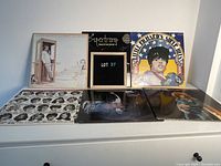 Six vinyl records displayed in original sleeves, showing front covers including Jimmy Buffett's Coconut Telegraph, Supertramp's Crime of the Century, and Little Richard's Super Hits among others.