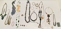 Full assortment of costume jewelry laid flat showing necklaces, bracelets, rings, and earrings in varied styles and colors.