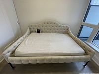Front view of daybed showing tufted headboard and mattress placeholder