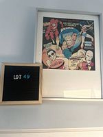 Overall view of framed comic print with lot number board beside it