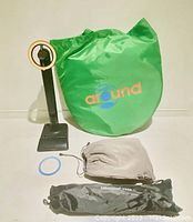 Photo of a microphone-equipped camera on a stand with a green Round branded carrying bag, a drawstring pouch and a UBeesize tripod bag.