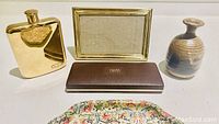 Desk accessory set including gold plated flask, gold tone picture frame, brown bud vase, Cross pen set case, and colorful decorative tray