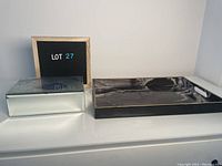 Photo of mirrored jewelry box and decorative tray side by side on white surface