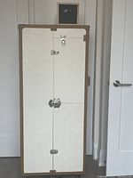 Closed trunk, front view showing exterior embossed pattern, chrome latches and caramel edging