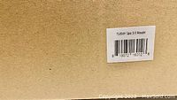 Sealed plain brown cardboard box with label 'TUSHY Spa 3.0 Royale' and barcode on the side