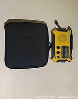 Closed black Motorola carrying case with embossed logo and Kaito Voyager emergency radio beside it