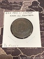 Photo of obverse side showing the Bank of Montreal crest with '1844' and '1/2 Penny' noted on the cardboard holder.