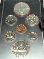 Photo of Canadian coin set in black case showing seven coins including a silver dollar, quarter, dime, nickel, and penny.
