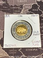 Reverse side of the 1998 Canadian $2 Twoonie coin featuring a gold-plated polar bear design and the $2 denomination on silver outer ring.