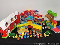 Full set of all playsets and figures arranged on black background, including two barns, a ship, tree fort, and Kid figures.
