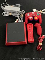 Full lot showing Nintendo Wii Mini console, power adapter, composite AV cable, red Wii Remote, red Nunchuk, and red GameCube controller.