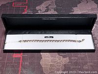 Bracelet displayed in its Warren James branded box on a map background, showing full length and presentation packaging.