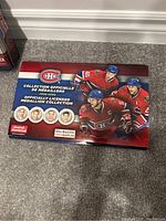 Red medallion collection box featuring images of three Montreal Canadiens players and five metallic medallions with faces.