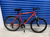 Side view of red Diamondback adult mountain bike showing frame, drivetrain, tires and fenders