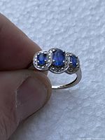 Close-up front view of the ring showing three oval faceted blue stones with beaded detail along the edges